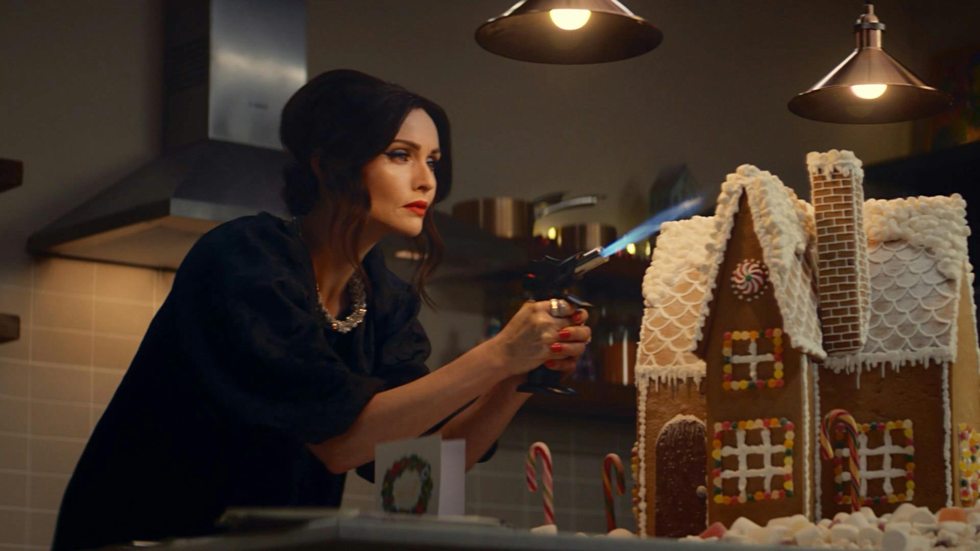 Still from the M&S Christmas 2023 advert showing Sophie Ellis Bextor blowtorching icing on a gingerbread house