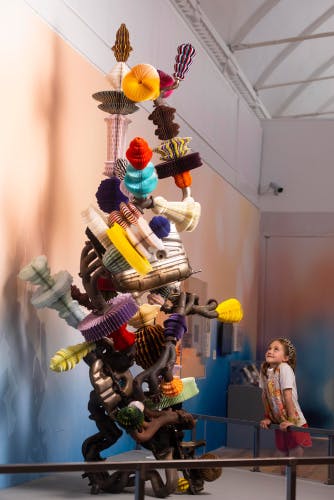 Install photo of a child looking at a tall layered structure the exhibition Japan: From Myths to Manga at the Young V&A