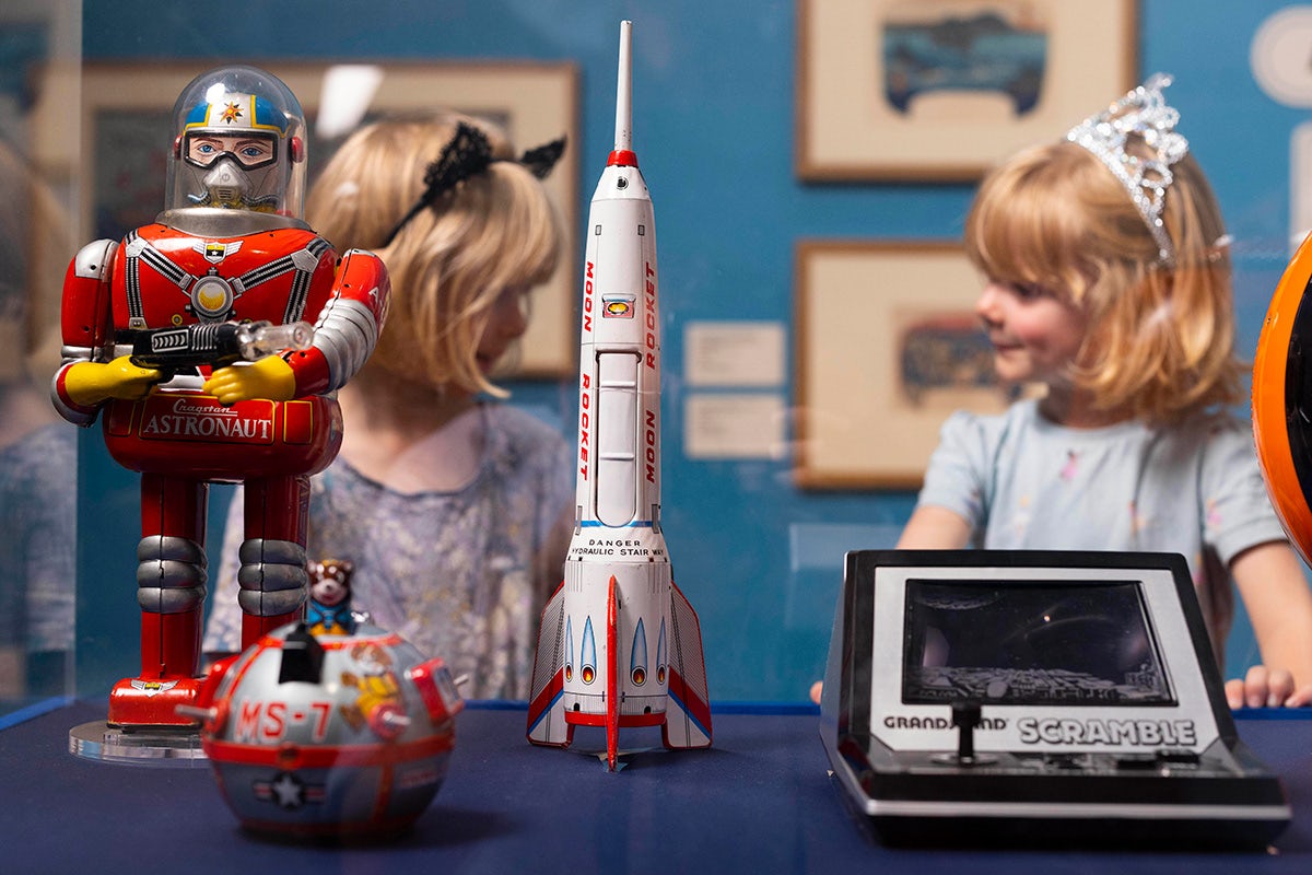 Photo of two children standing behind a display of rocket and robot figurines at the exhibition Japan: From Myths to Manga at the Young V&A