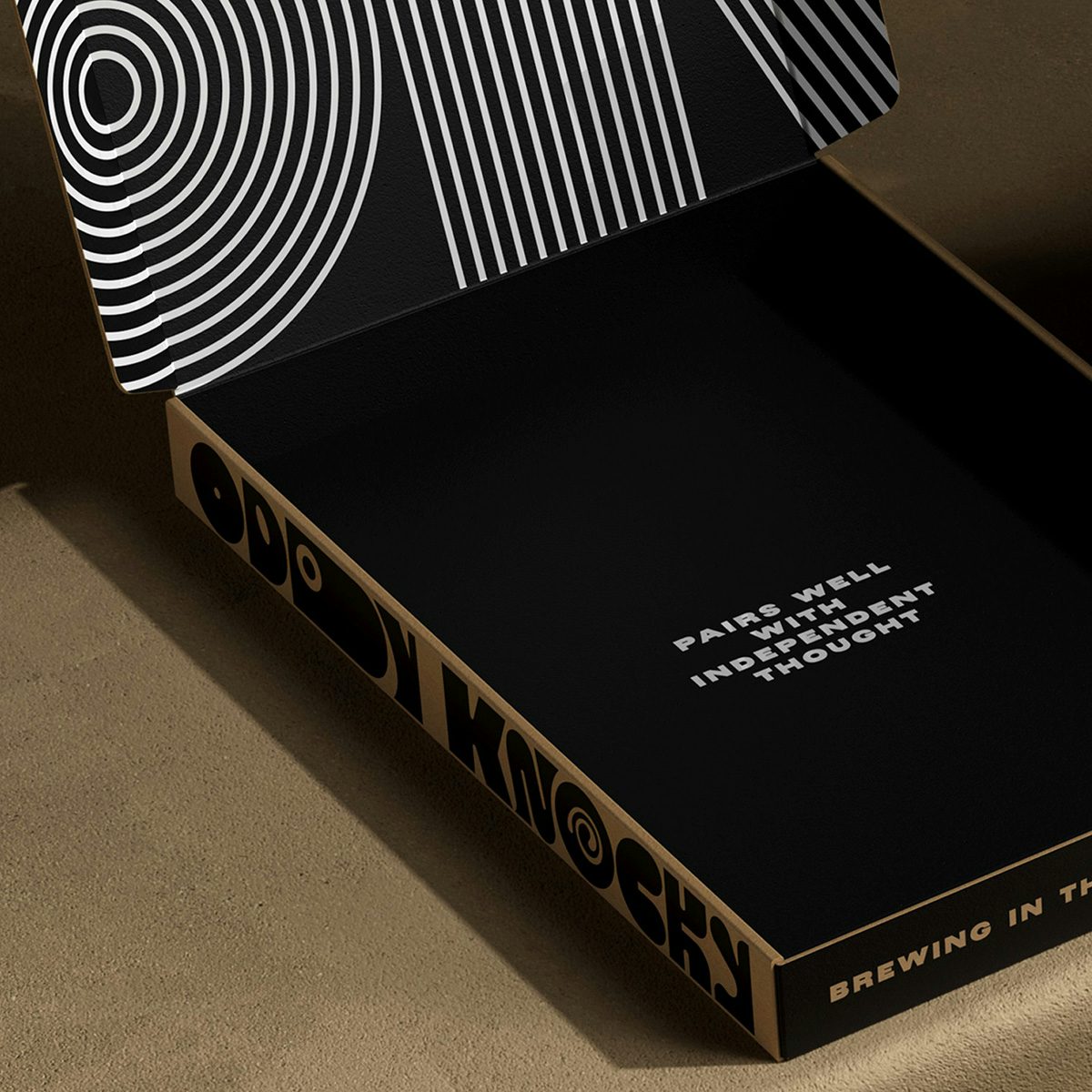 Photo showing the branding for Oddy Knocky on a box inscribed with the words 'Pairs well with independent thought' on a black background