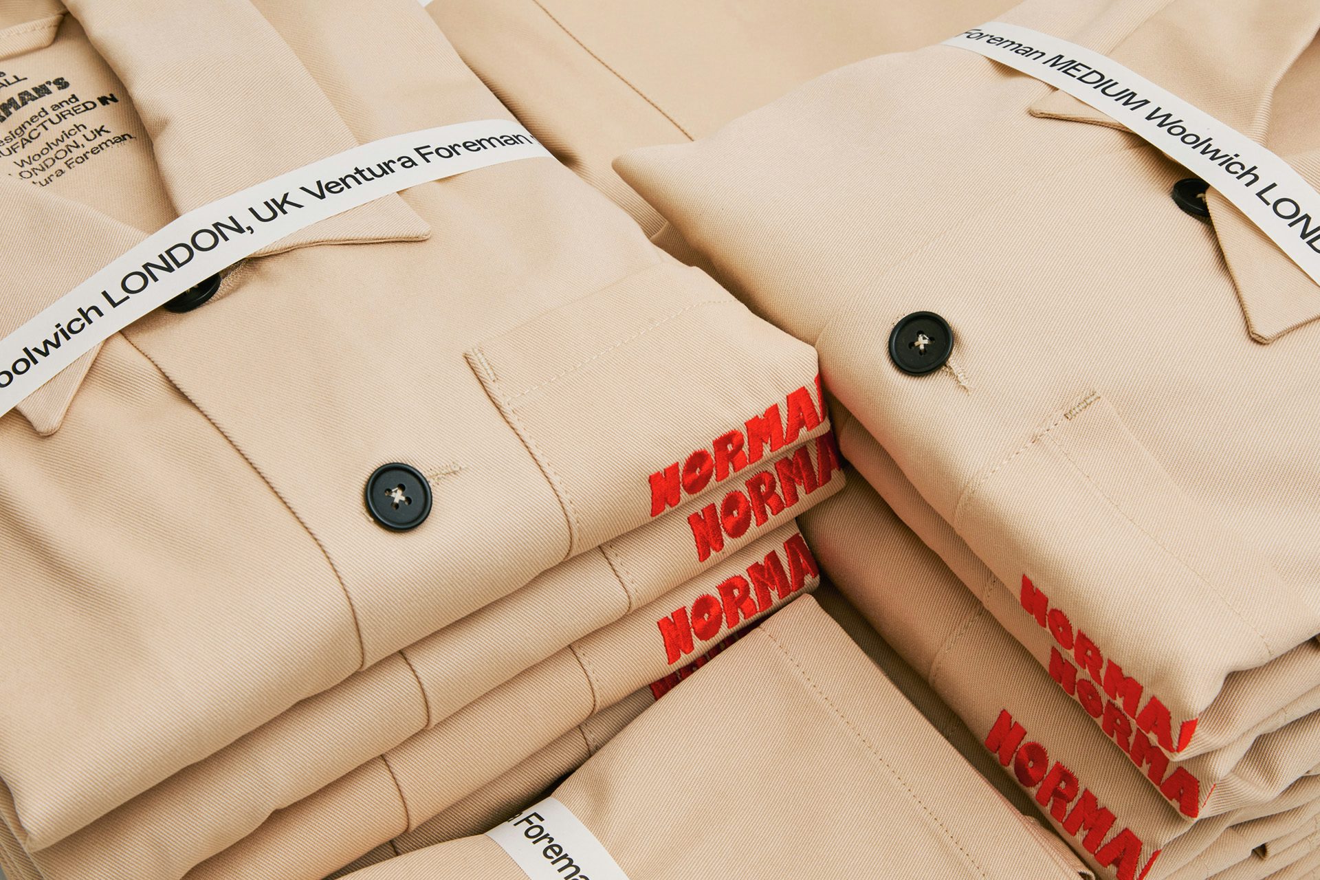 Photo showing Ventura Foreman's identity by Studio Blackburn on a thin label wrapped around sand toned shirts