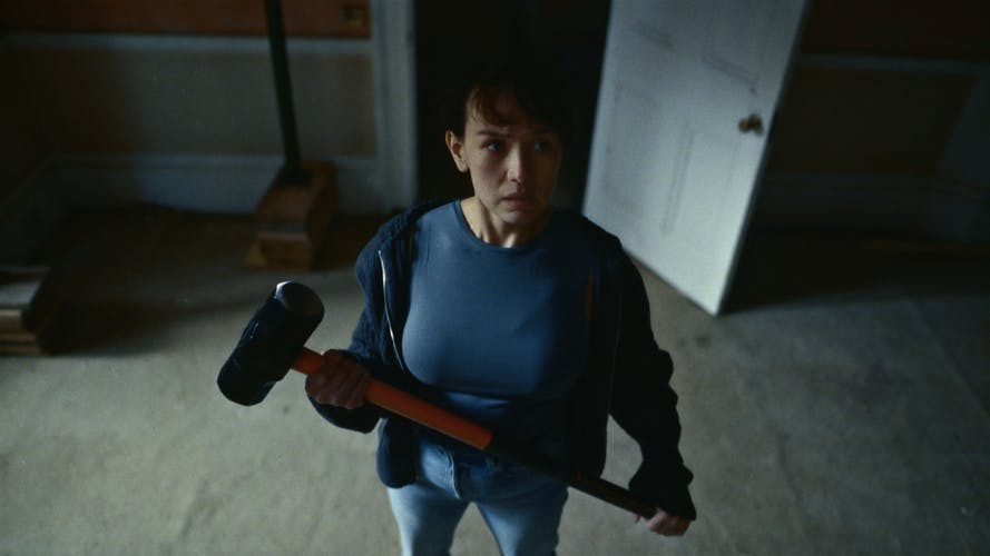 Still from B&Q You Can Do It ad showing a woman looking up towards the camera holding a sledgehammer