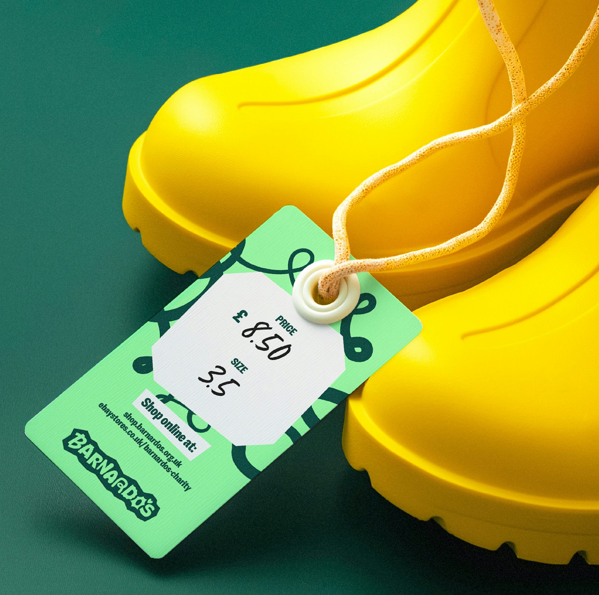 Image shows the new Barnardo's visual identity on a green clothing tag attached to yellow rubber boots
