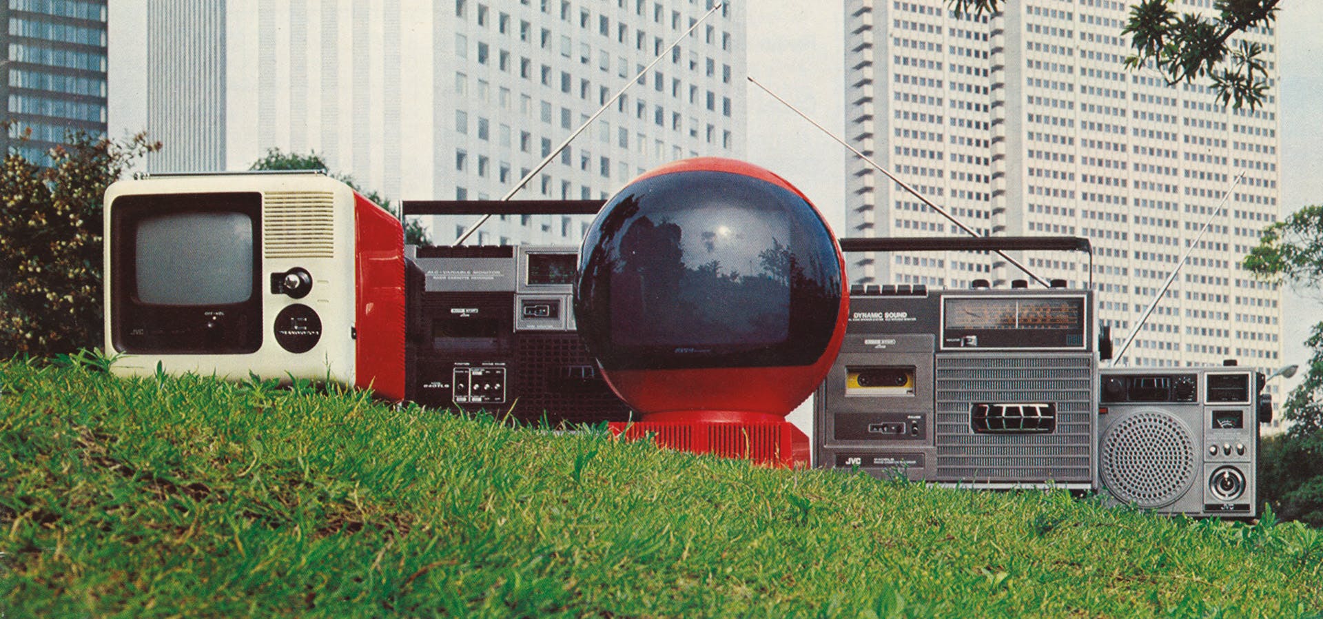 Audio hi-fi equipment on a patch of grass against a city backdrop