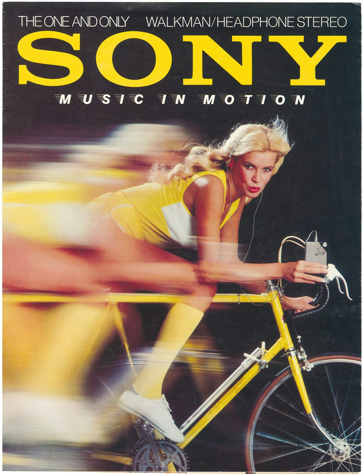 Sony Walkman poster showing a motion blurred image of a person dressed in yellow clothing and exposed legs while riding a bike and holding a walkman