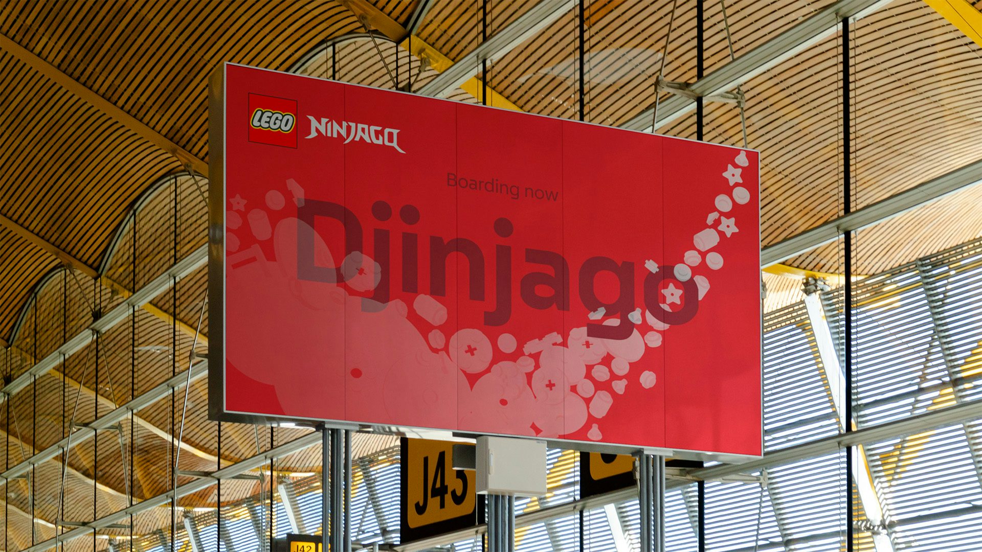 Image shows a large red horizontal poster that reads 'Djinjago' suspended from a wood panelled ceiling