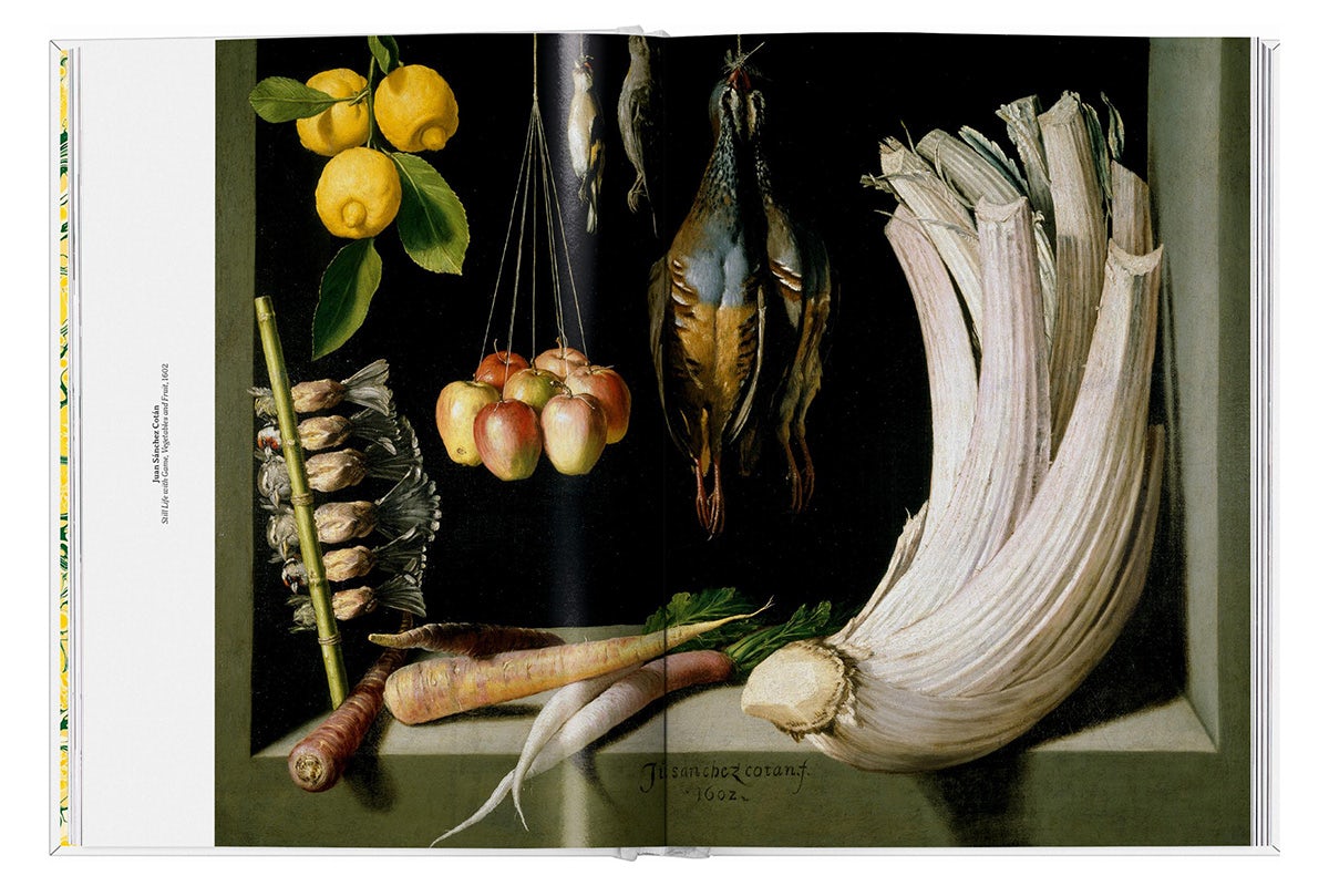 Image shows a still life artwork featuring various fruit and vegetables suspended and arranged over a table, which has been laid out over a double page spread in The Gourmand's new book, Lemon