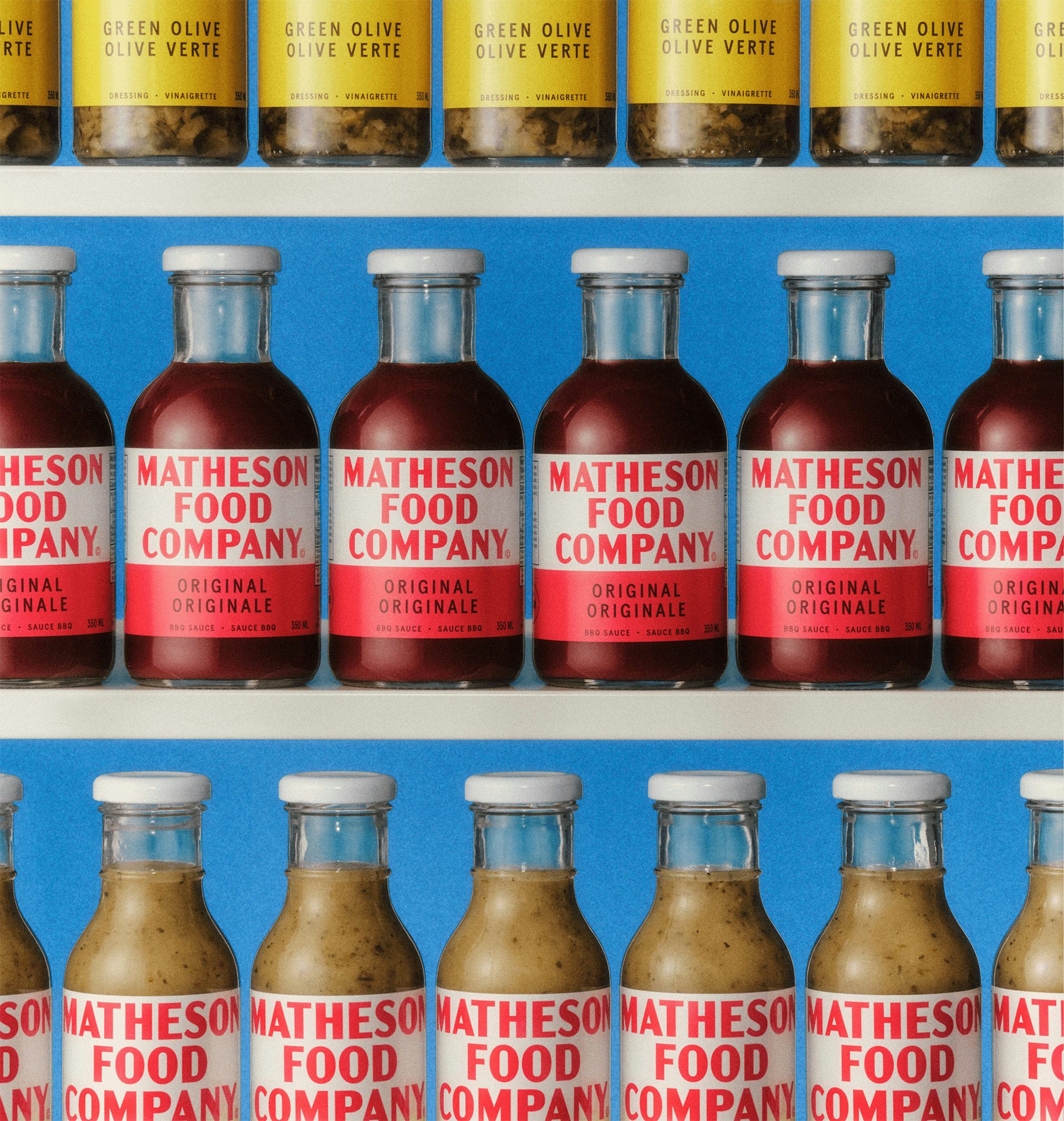 Image shows three rows of sauce bottles labelled with the new Matheson Food Company branding, which features a red uppercase wordmark