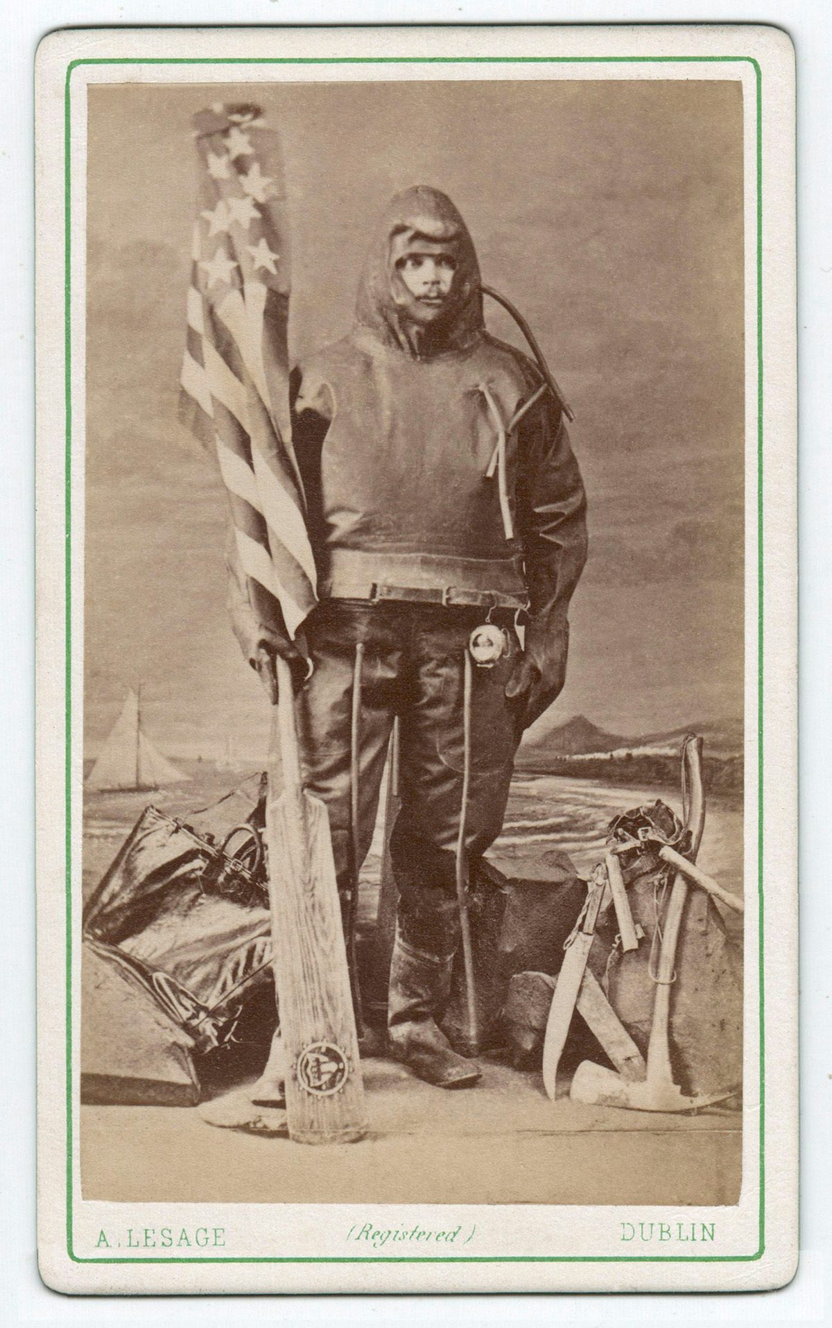 Sepia toned photograph of an explorer wearing specialist clothing holding a flag