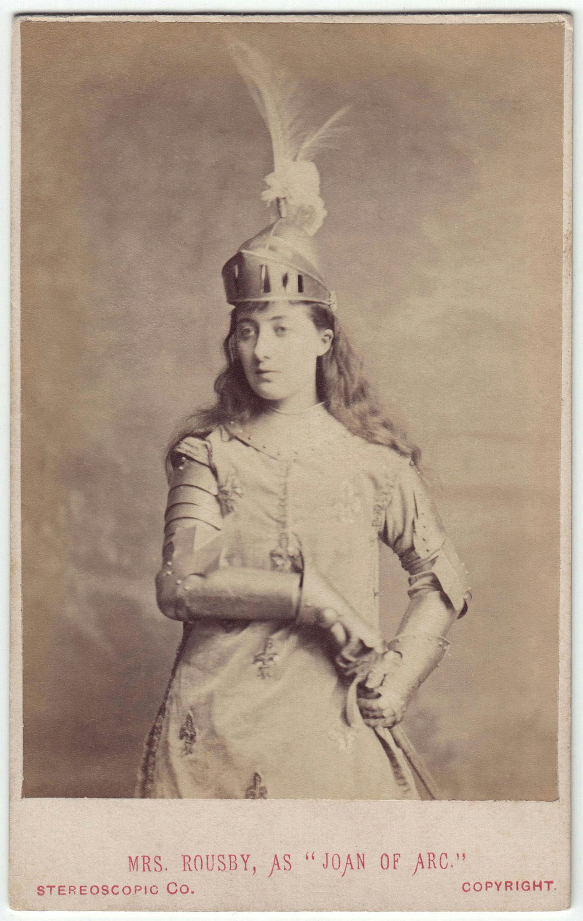 Sepia toned photo of a person with long hair wearing a head piece with feathers protruding from it