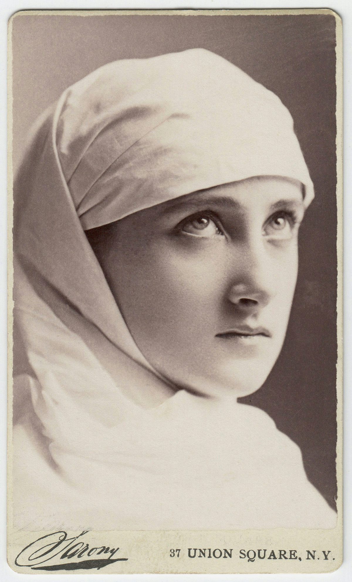 Sepia toned photo of actress Maud Branscombe wearing a white fabric headdress