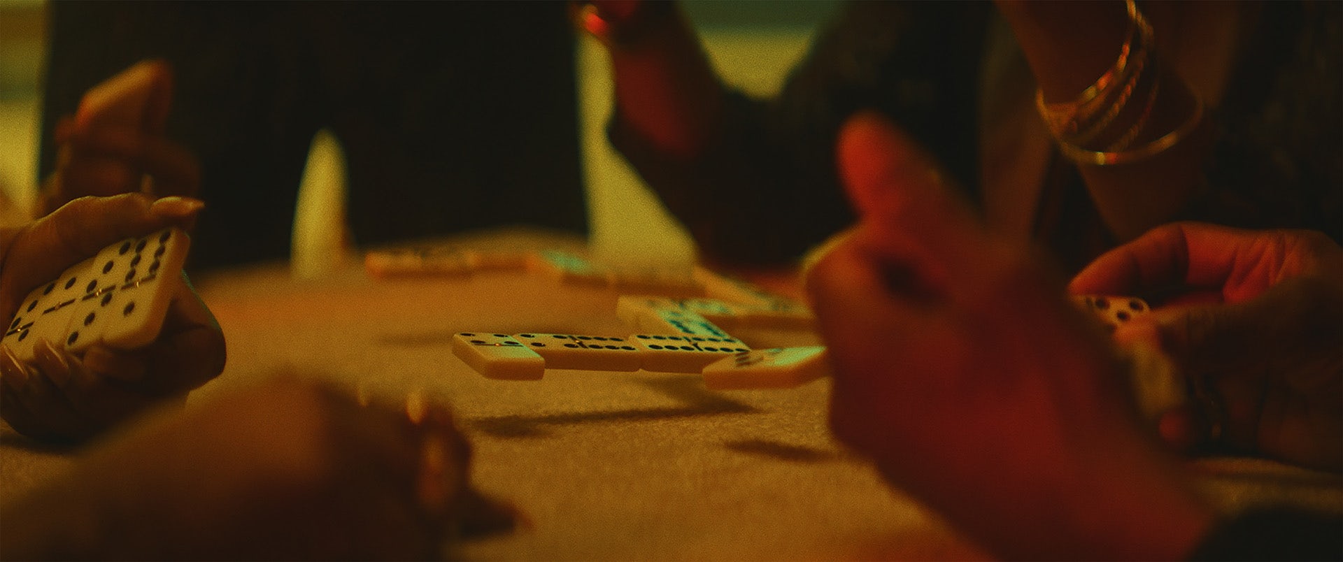 Close-up of people's hands as they play dominoes which are levitating above the tabletop