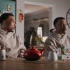 Ashley Walters sat next to another version of himself at a table with a teapot and PG Tips box on top, taken from the brand's new advert