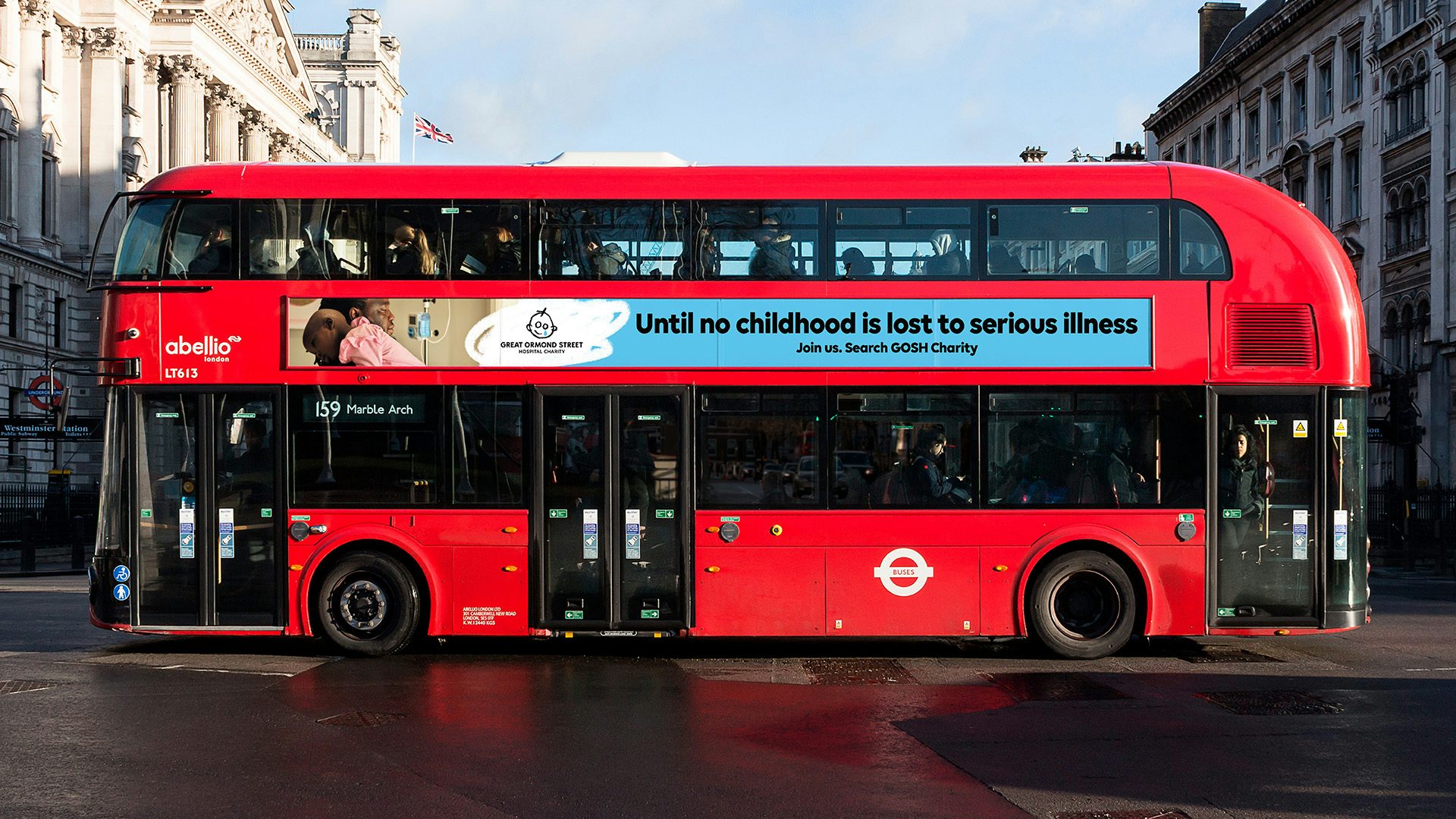 Red double decker bus showing an advert along the side for Great Ormond Street Hospital Charity that reads 'until no childhood is lost to serious illness'