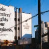 Wall Street Journal outdoor ad on the side of a building that reads 'make renters' rights your business' painted in black letters on a white background