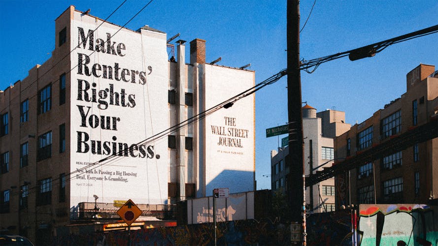 Wall Street Journal outdoor ad on the side of a building that reads 'make renters' rights your business' painted in black letters on a white background
