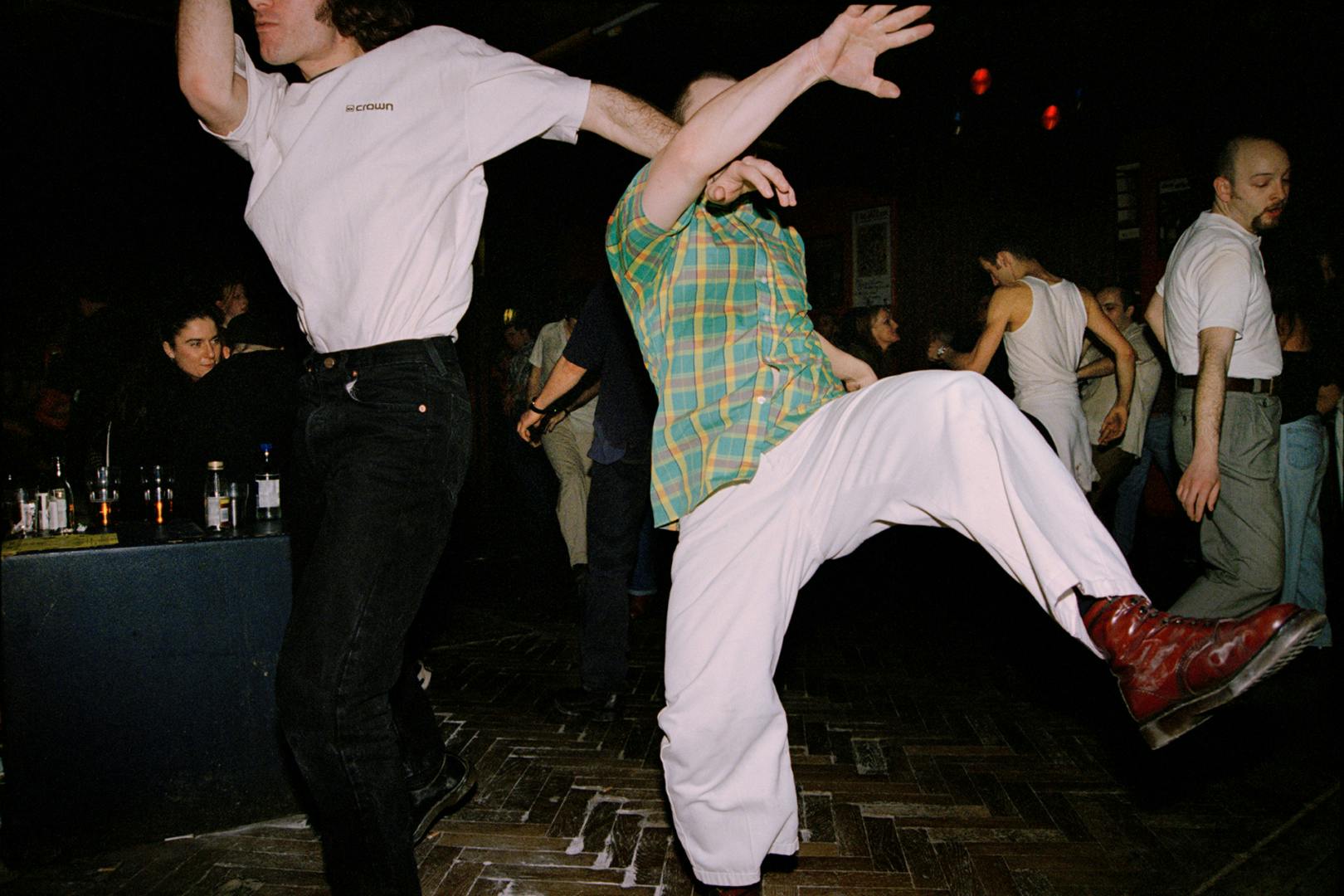 Two people dancing exuberantly in a hall