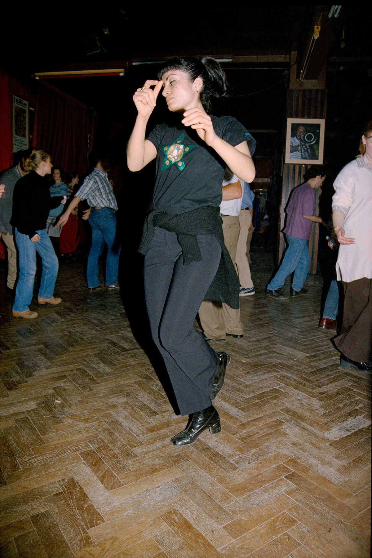 A person wearing all black dancing in a hall