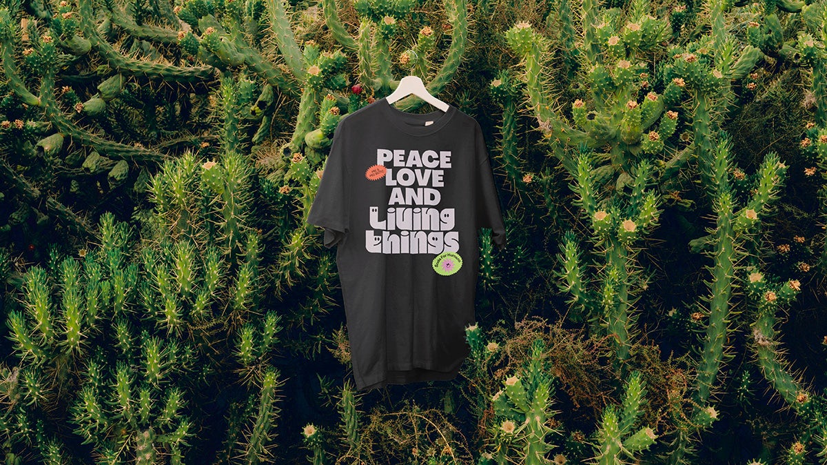 Black T-shirt that reads 'peace love and living things' against a leafy background