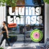 Living Things wordmark shown in thick white curvy letters on a glass office door