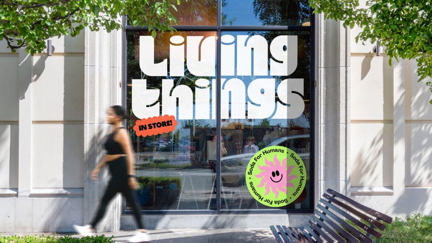 Living Things wordmark shown in thick white curvy letters on a glass office door