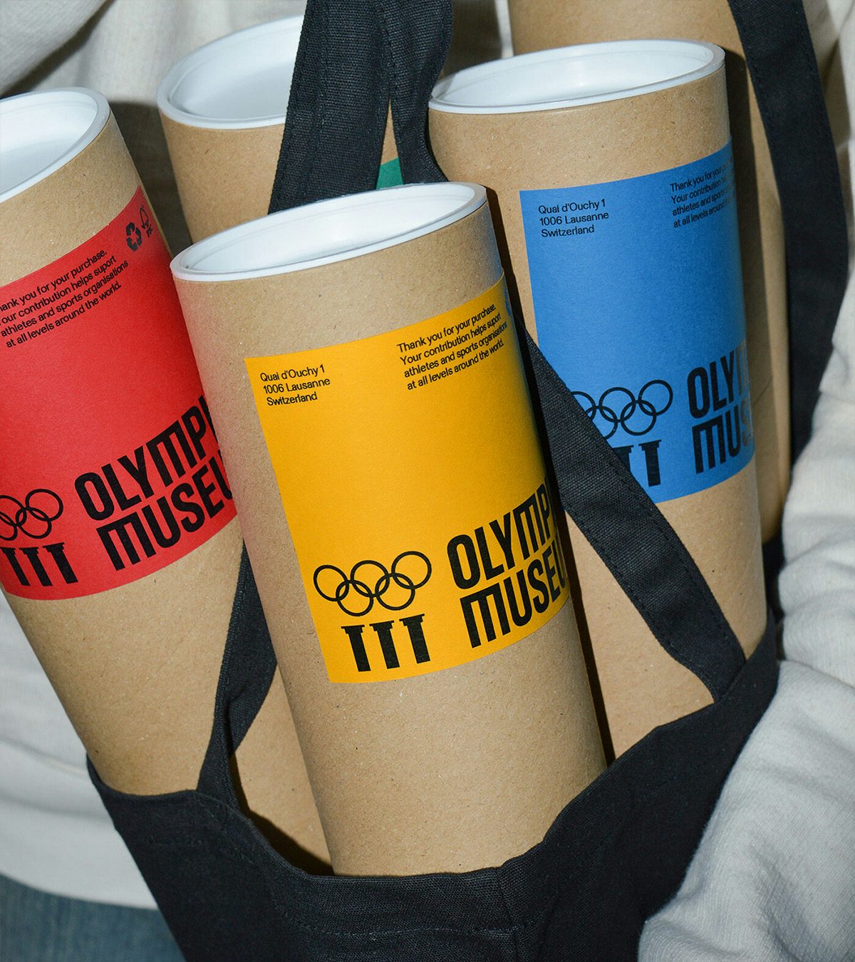 Poster tubes featuring the new Olympic Museum identity in red, yellow and blue labels