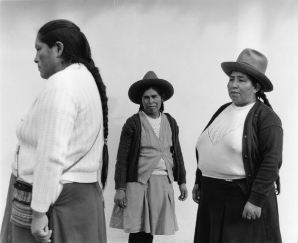 Black and white photo by Ana Margarita Flores of three Peruvian women facing in different directions against a misty backdrop