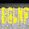 Wordmark that reads 'BGLNF' laid out in yellow tall angular letters, shown against a grey pebbledash background