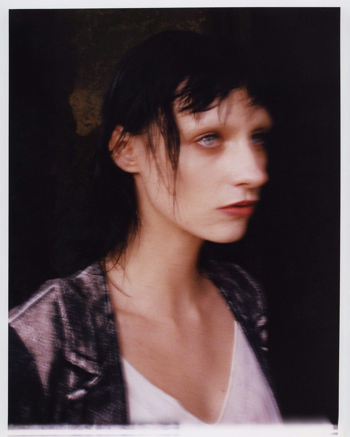 Blurred portrait of a person with dark hair and red lips
