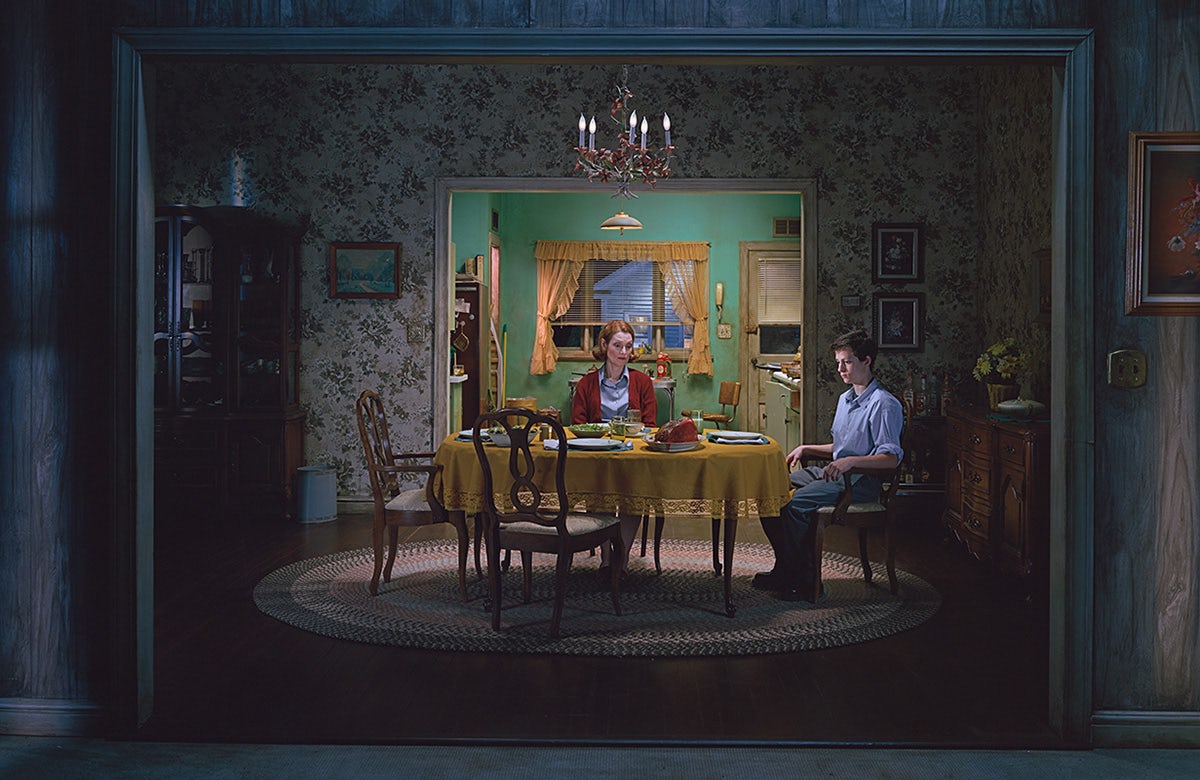 Two people sat woodenly around a dining table