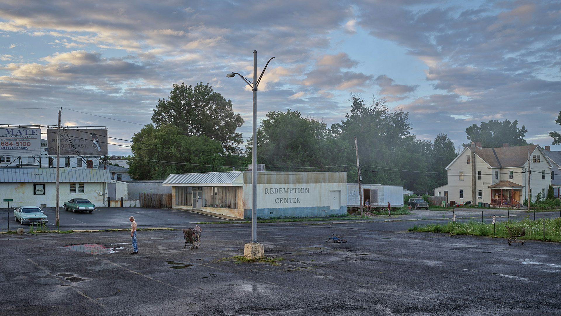 A person standing alone in a desolate car park