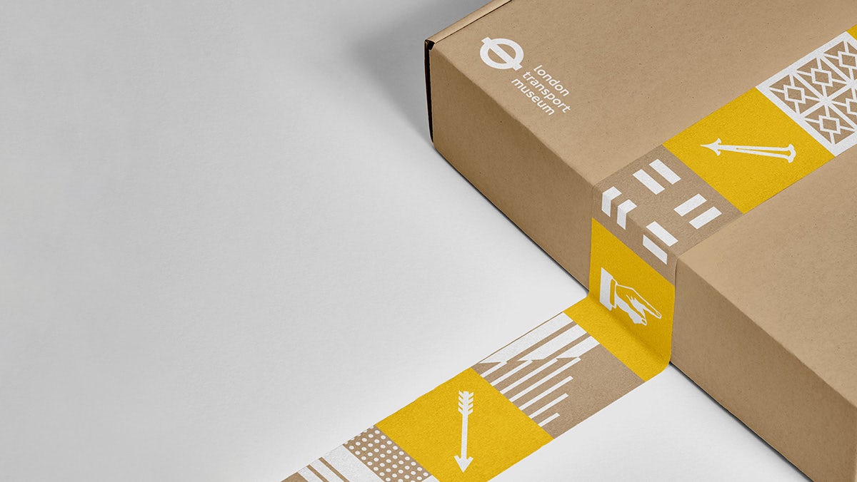 A London Transport Museum packaging box featuring yellow and brown branded parcel tape