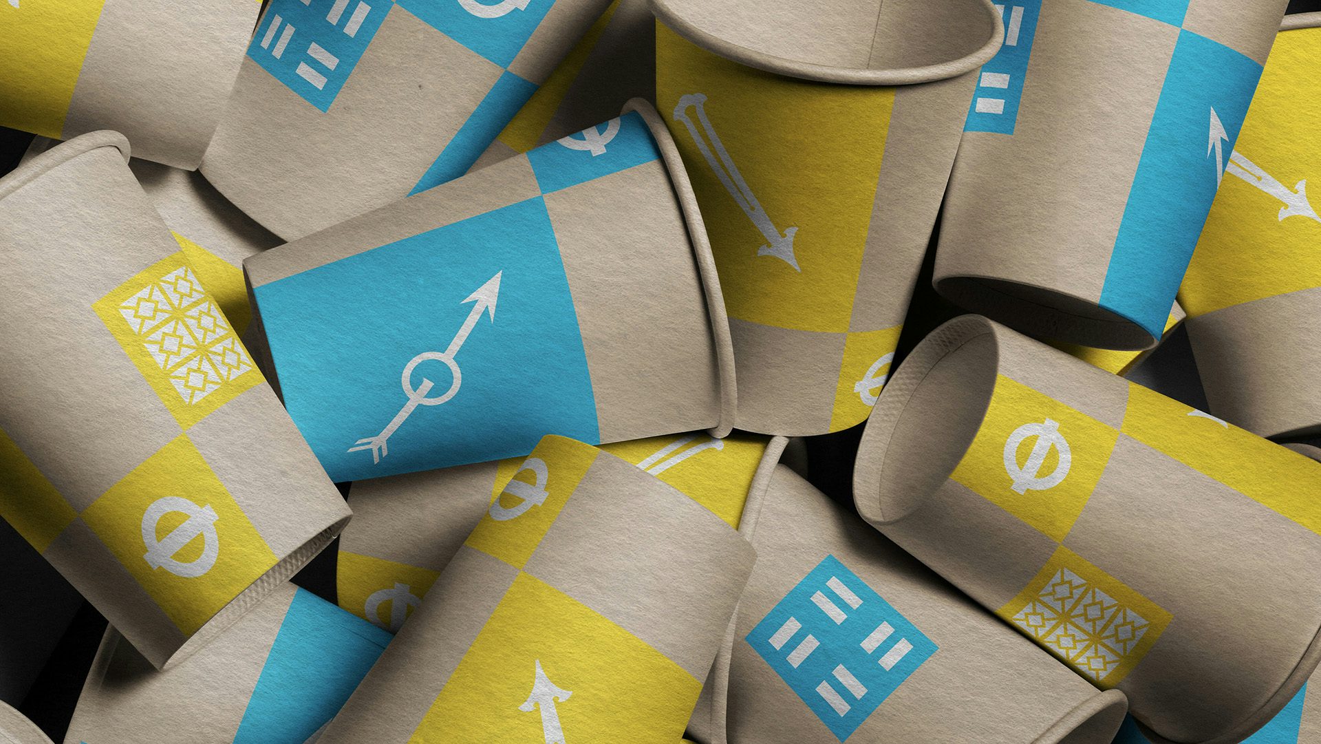 A pile of brown, yellow and blue paper cups featuring London Transport Museum branding