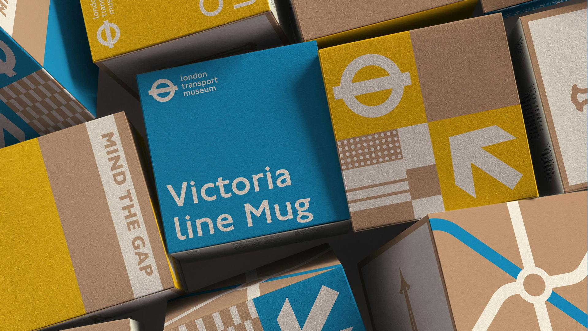 A pile of cube shaped packaging boxes in a palette of brown, blue and yellow, featuring London Transport Museum packaging