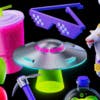 3D illustrations of Twitch brand motifs including a UFO, a pink cup and straw, a goat, and sunglasses