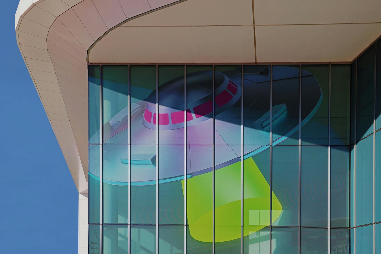 Glass exterior of a building with a UFO motif decorated over the glass