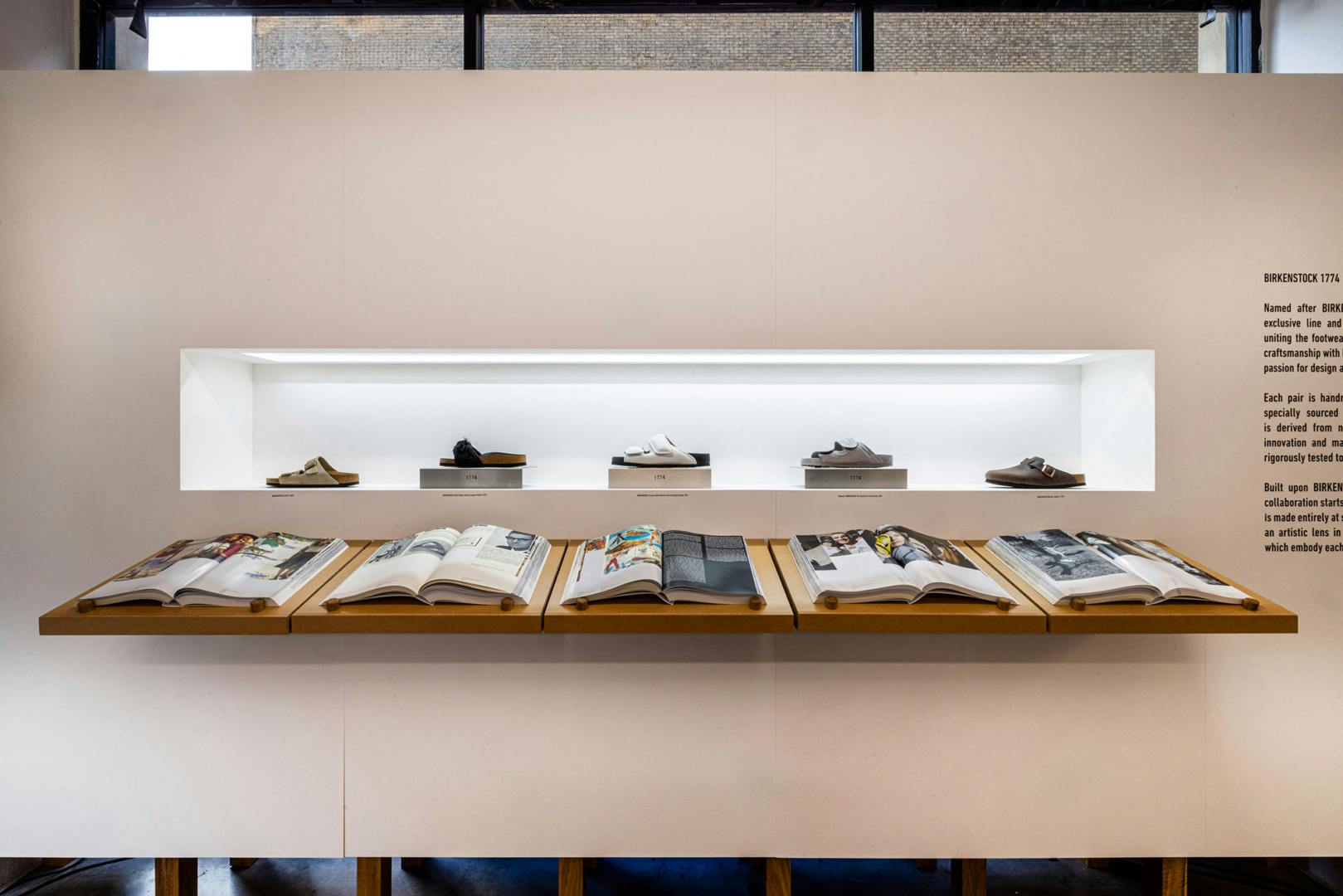 A line of shoes appear next to a line of books at Birkenstock's 250-year anniversary photo exhibition