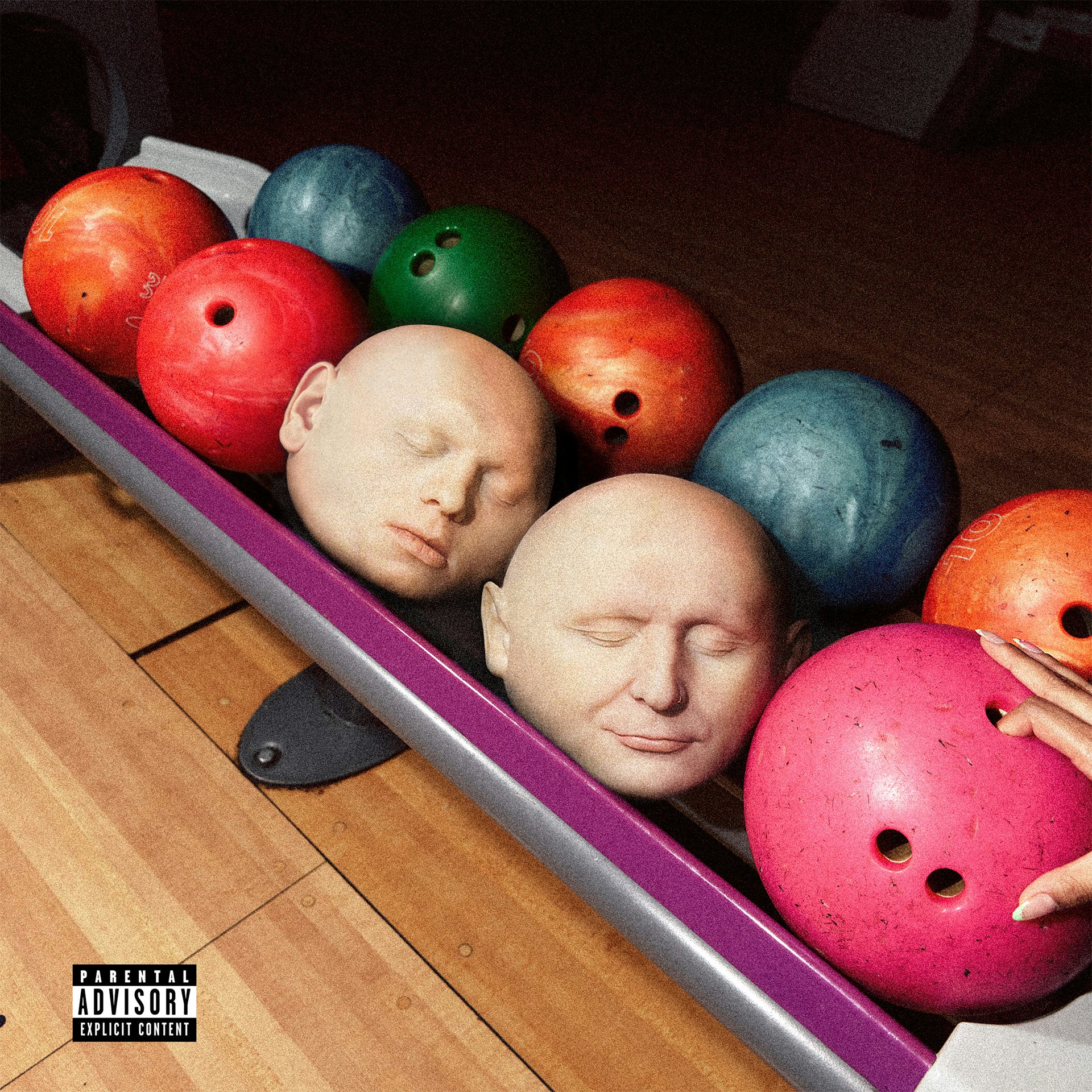 A rack of bowling balls, two of which have realistic faces