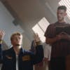 Still from the Aries and Arsenal collaboration campaign film showing Martin Odegaard kneeling on the ground appearing to pray and Declan Rice appearing to read from a holy book next to him