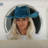 Still from a Levi's advert showing Beyoncé with blonde hair and wearing a raw denim cowboy hat standing in front of a washing machine in a laundrette