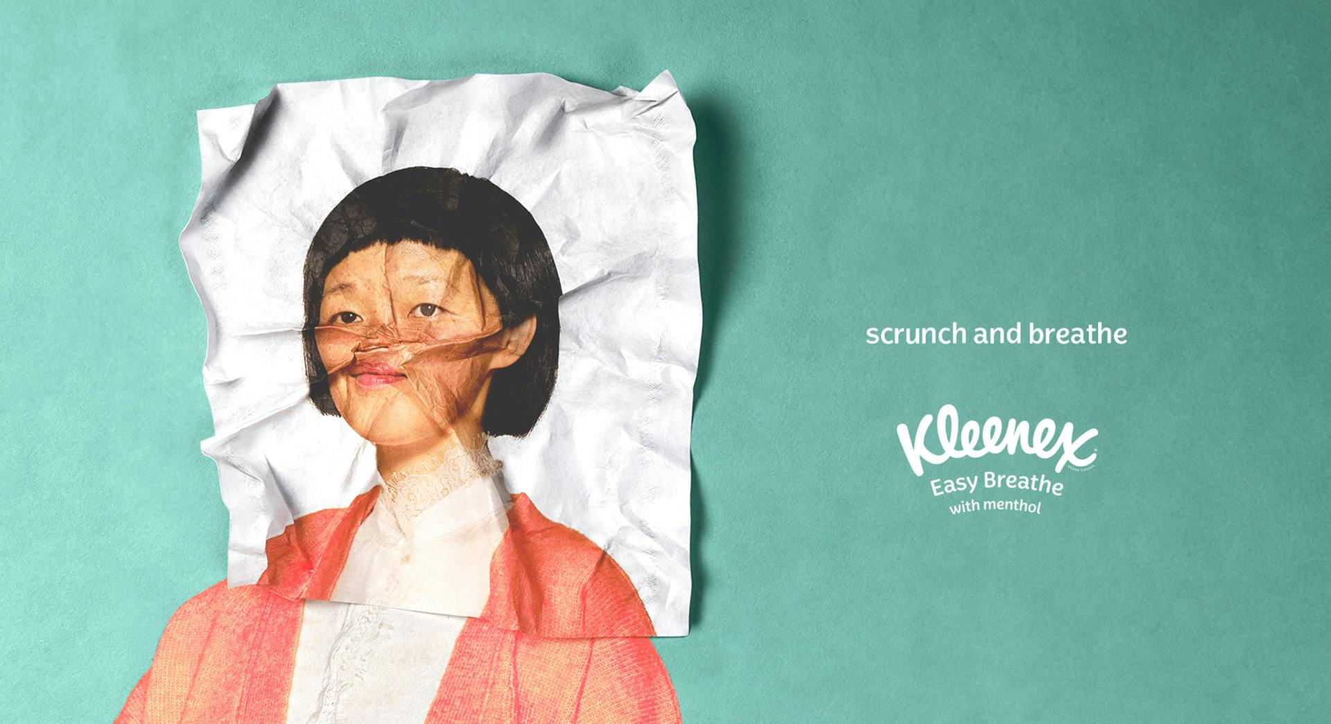 A Kleenex advert showing the torso of a person and the rest of their face printed onto a scrunched up tissue that's laid over the top