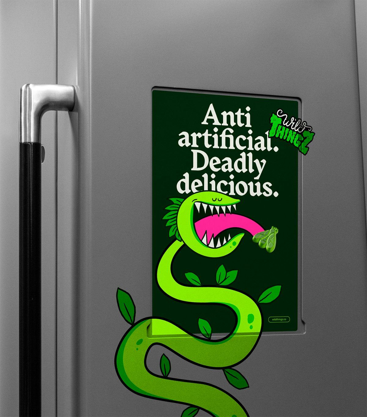 A silver surface featuring a poster headlined 'Anti artificial, deadly delicious' and a green venus flytrap cartoon which appears to run off the poster onto the surface beneath