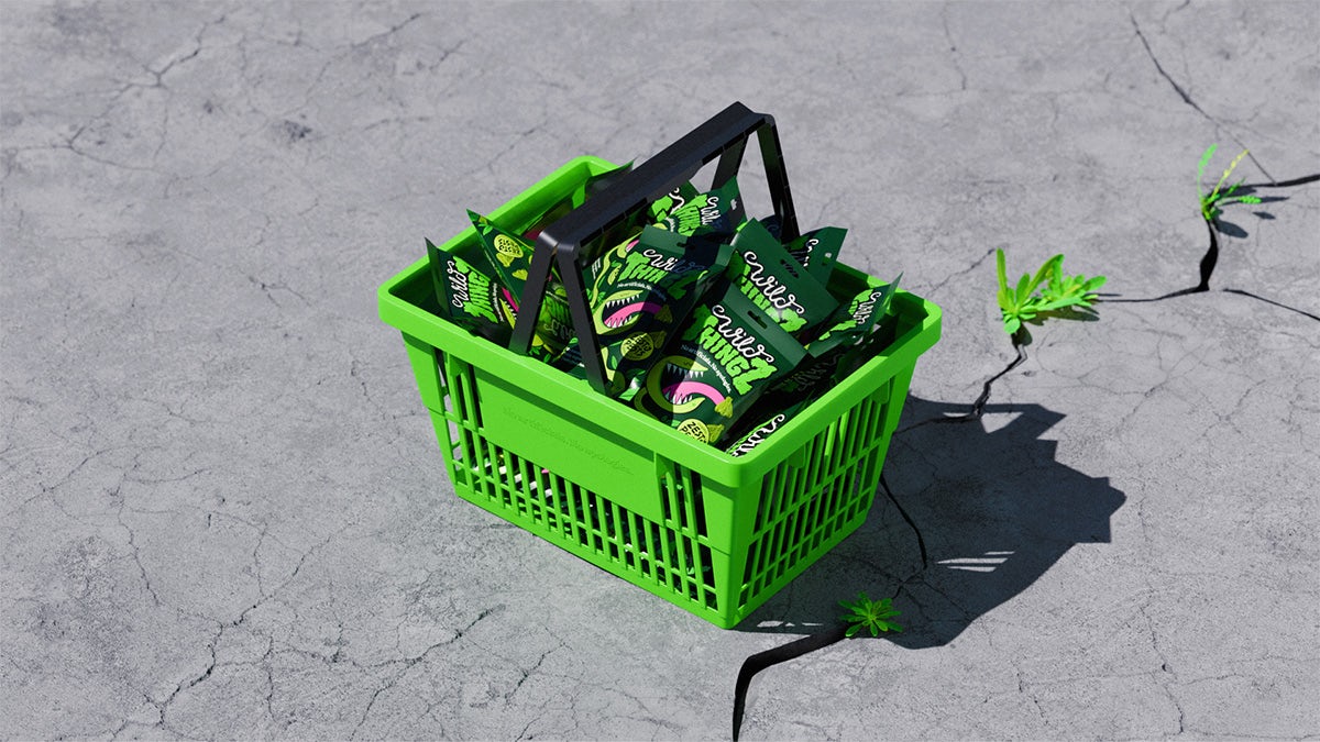 A green shopping basket filled with packets of Wild Thingz sweets