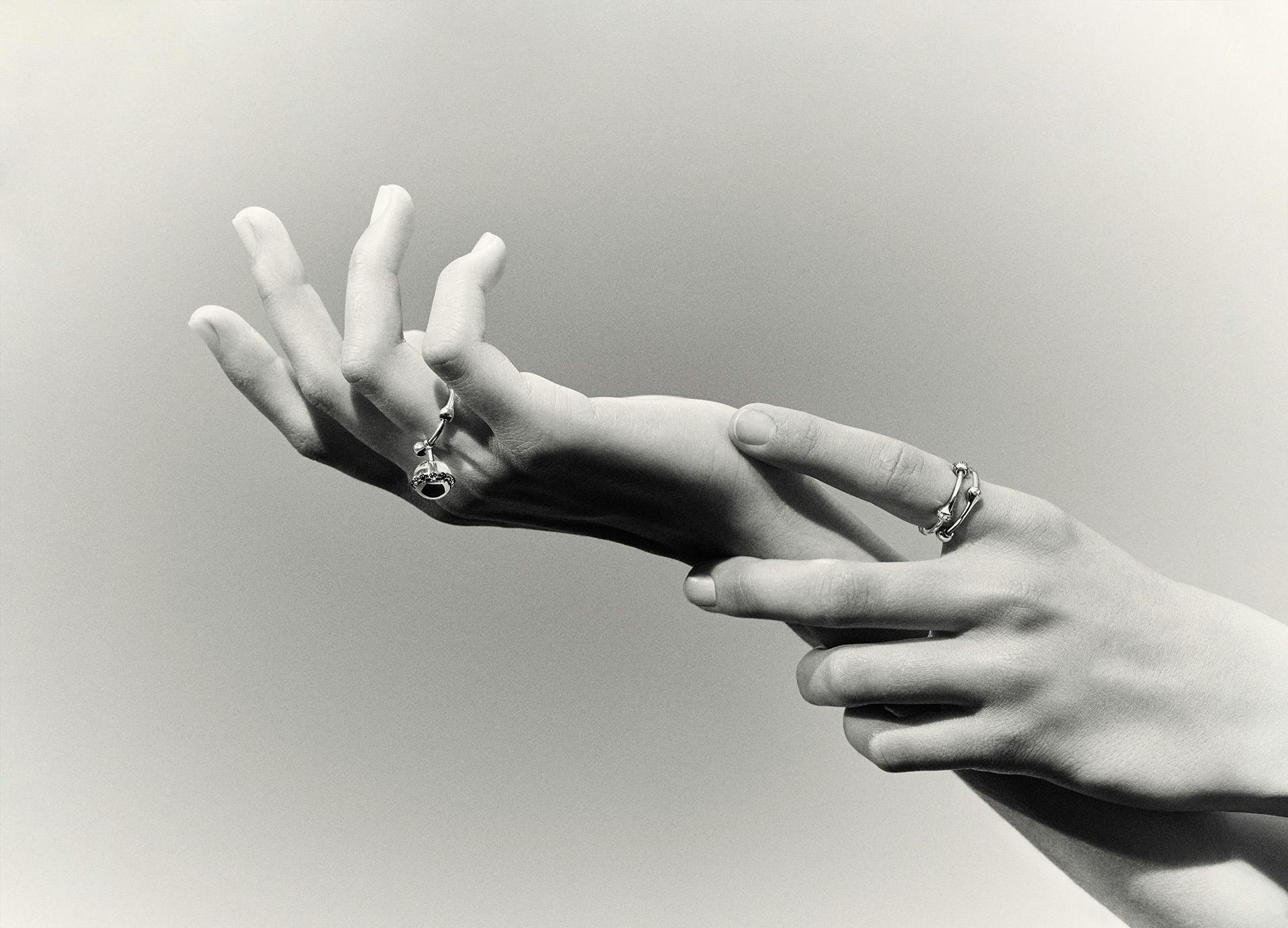 Black and white photo of a person holding out their hands artfully