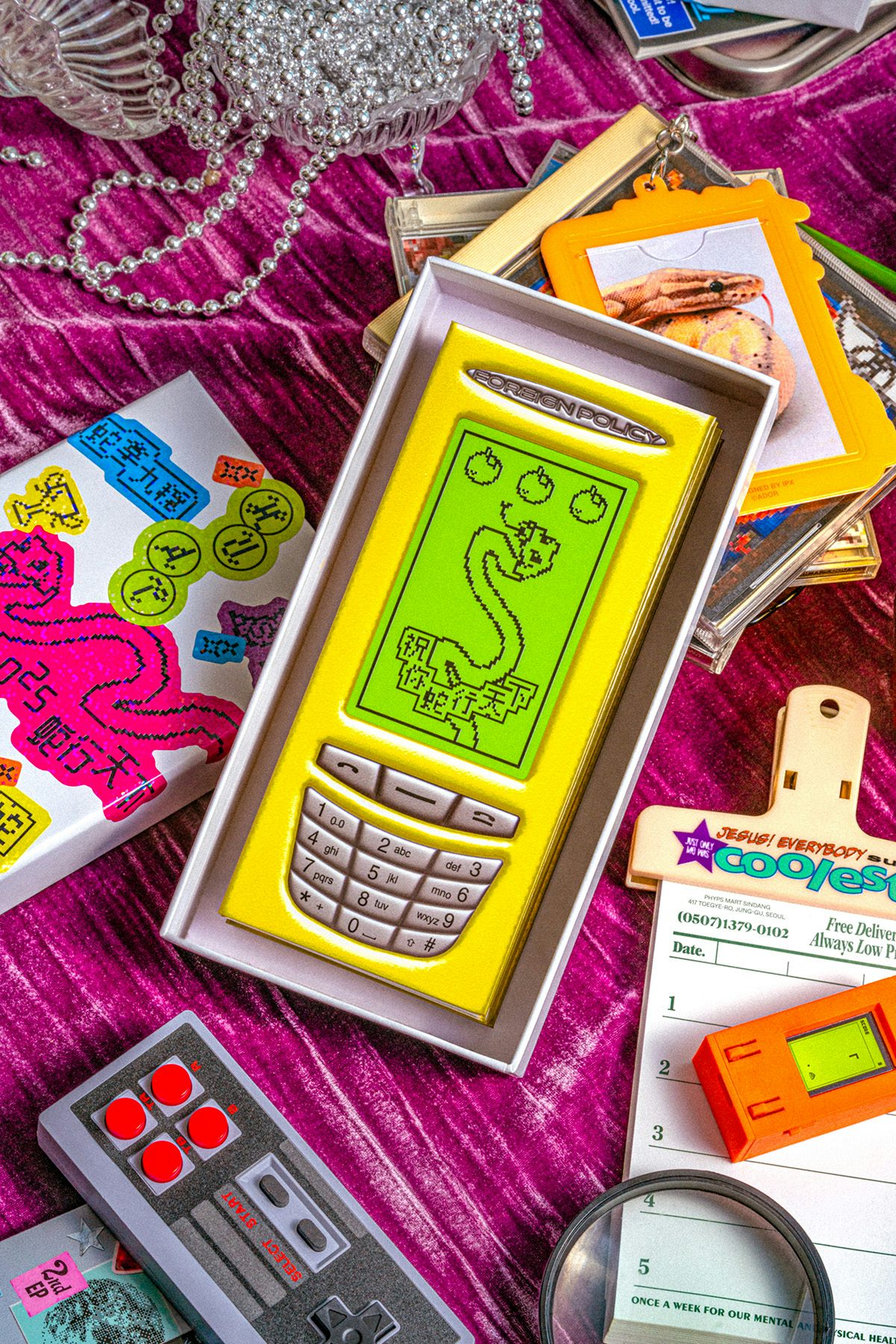 A table covered in a hongbao envelope designed in the style of a retro phone displaying a game of Snake