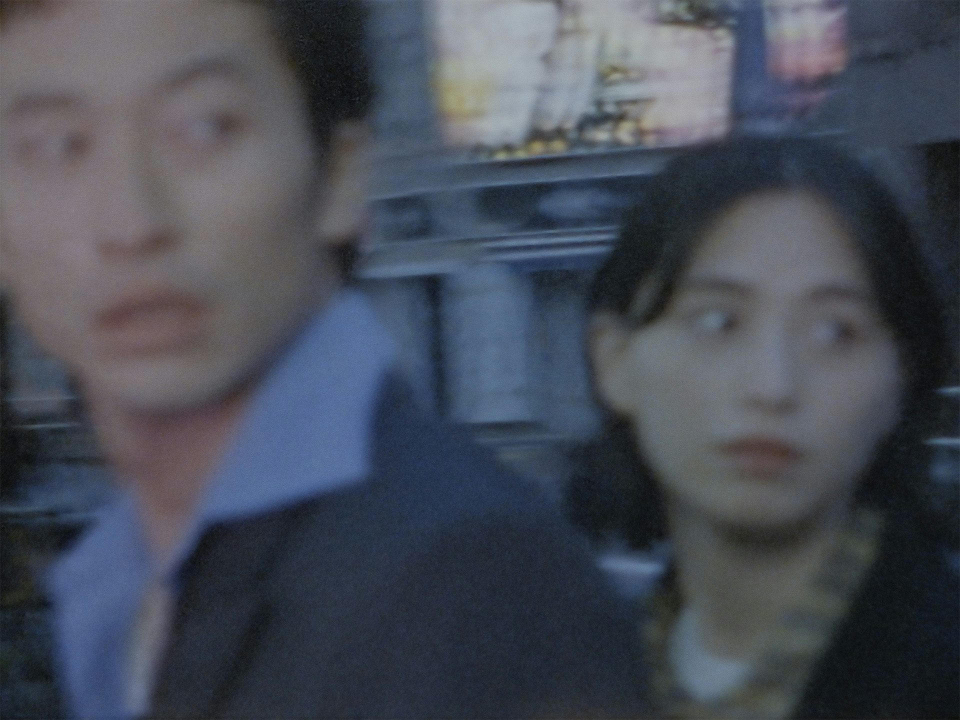 Still from Squid's music video Building 650 showing a blurred image of two young people glancing ominously