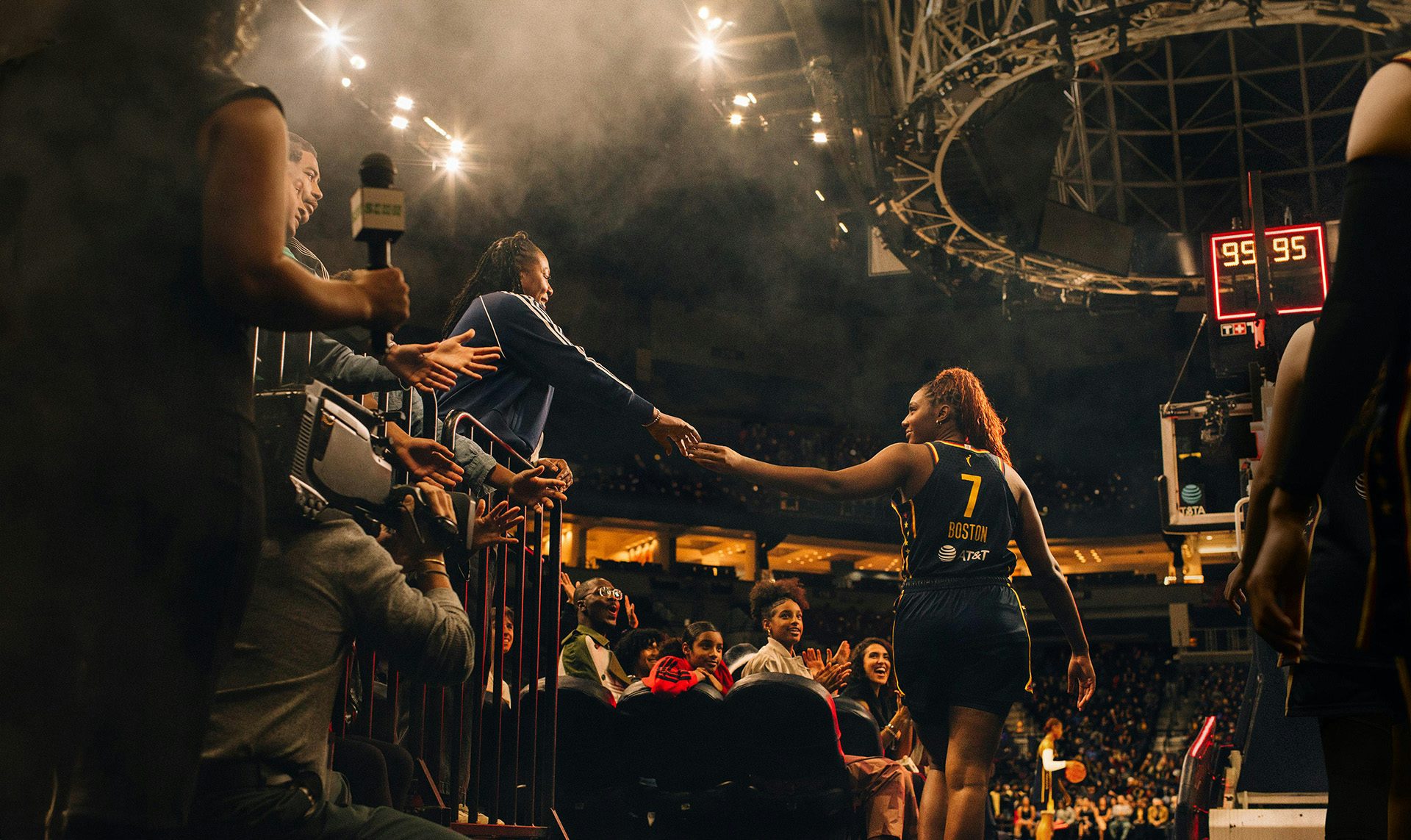 Still from adidas campaign showing Aliyah Boston on a basketball court high fiving a person in the stands