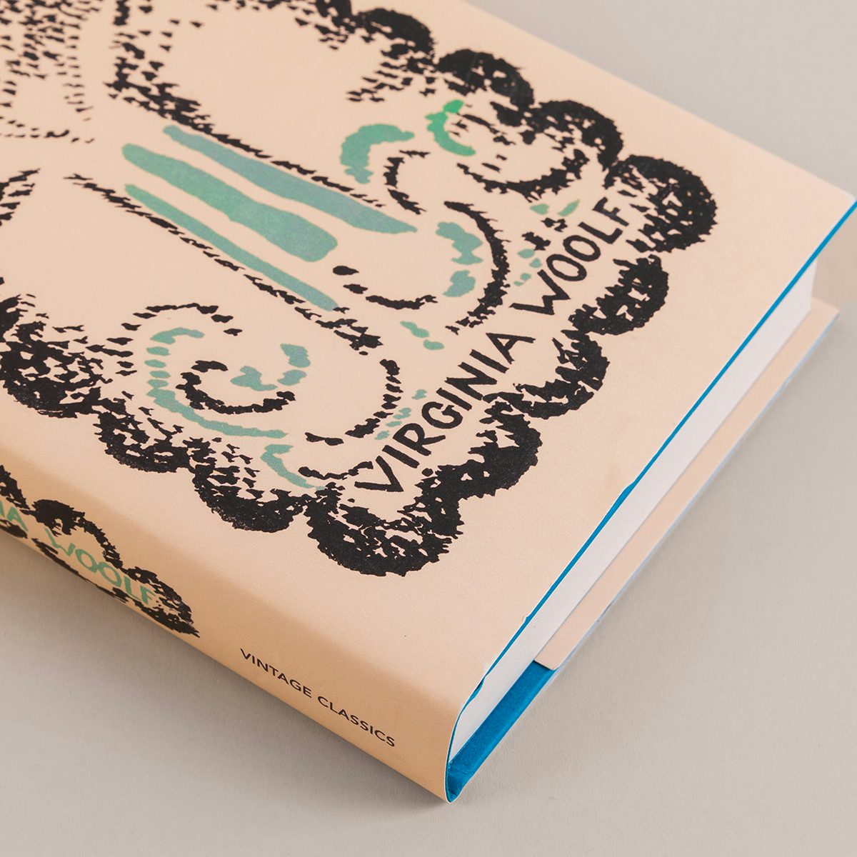 Cover of the Vintage Classics centenary edition of To The Lighthouse by Virginia Woolf featuring an black and blue woodcut design of a lighthouse in the sea by Vanessa Bell