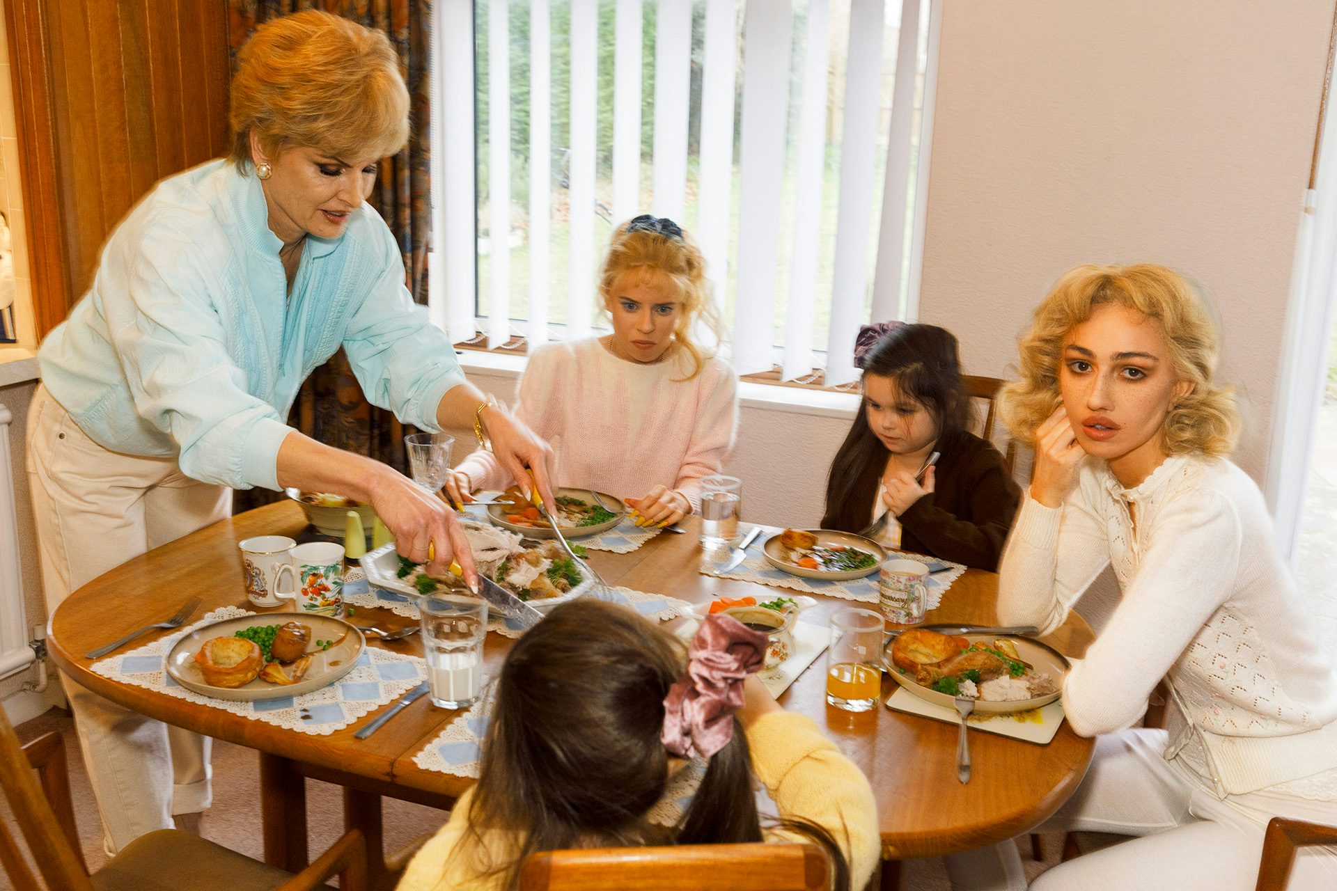 Photo from Julie Bullard by Nadia Lee Cohen and Martin Parr of a 90s style family gathered around a table eating a meal