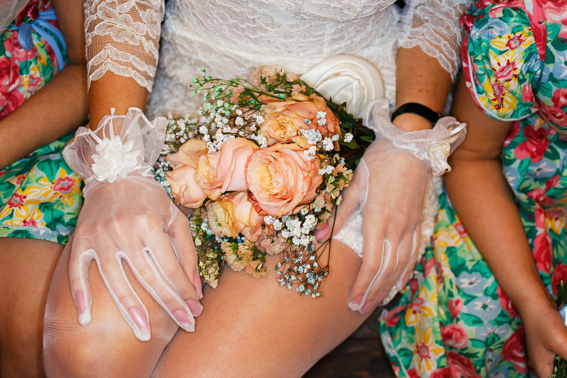 Photo from Julie Bullard by Nadia Lee Cohen and Martin Parr of a person wearing a short white lace dress resting a bouquet of flowers on their lap